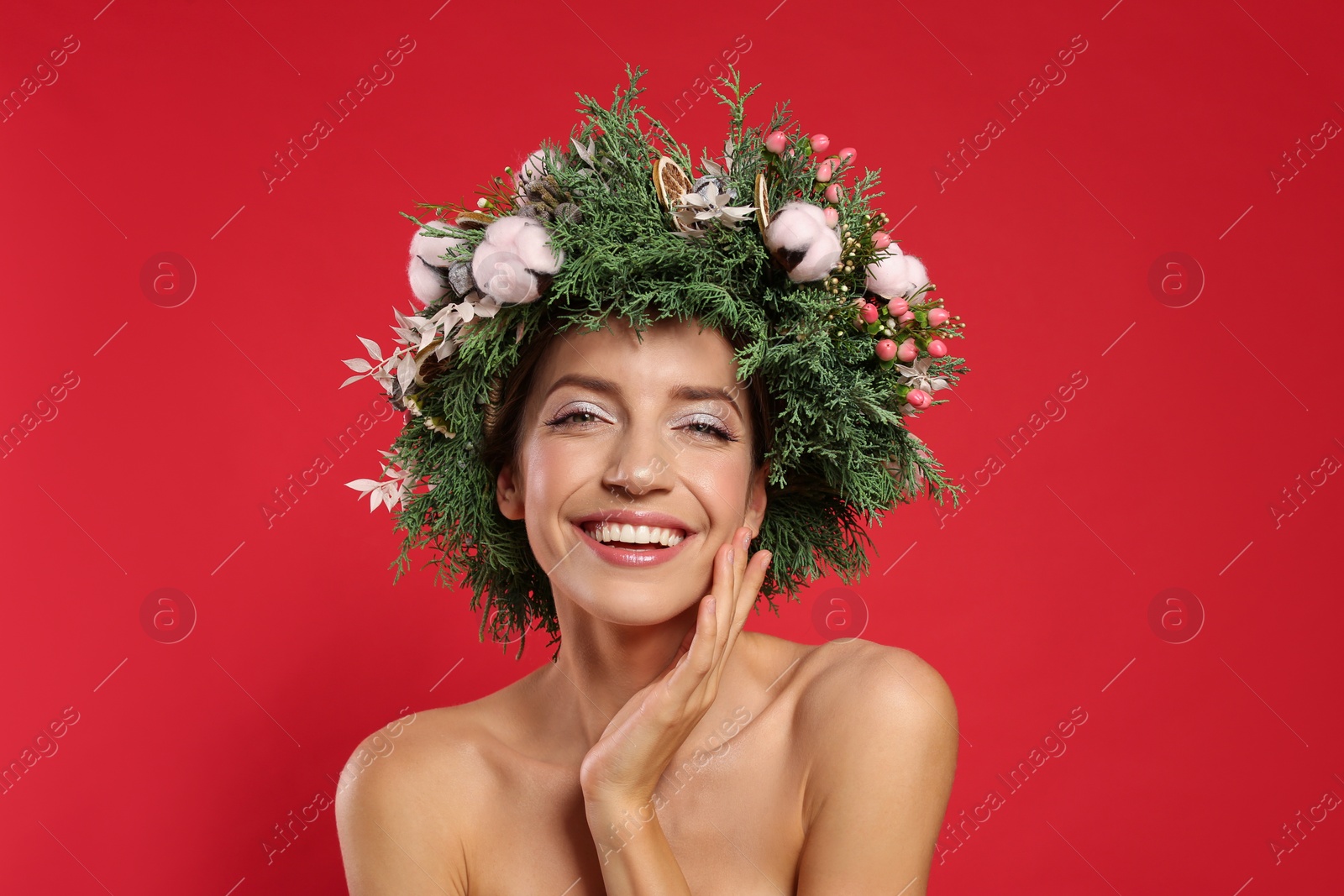 Photo of Happy young woman wearing wreath on red background