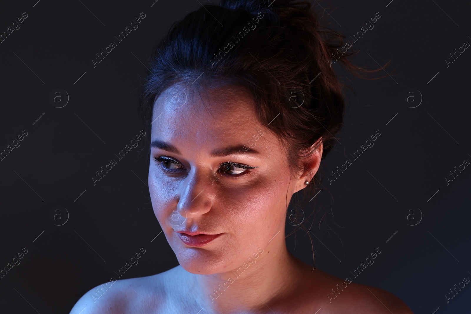 Photo of Portrait of beautiful young woman on dark background