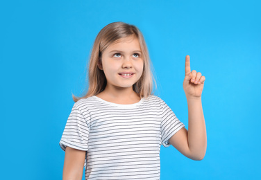 Cute little girl on light blue background