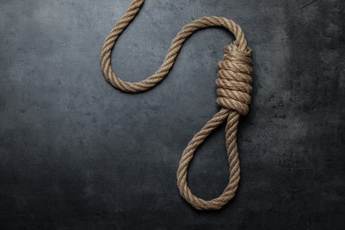 Photo of Rope noose with knot on black table, top view