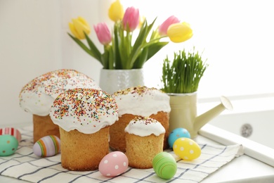 Photo of Traditional Easter cakes and dyed eggs on kitchen counter