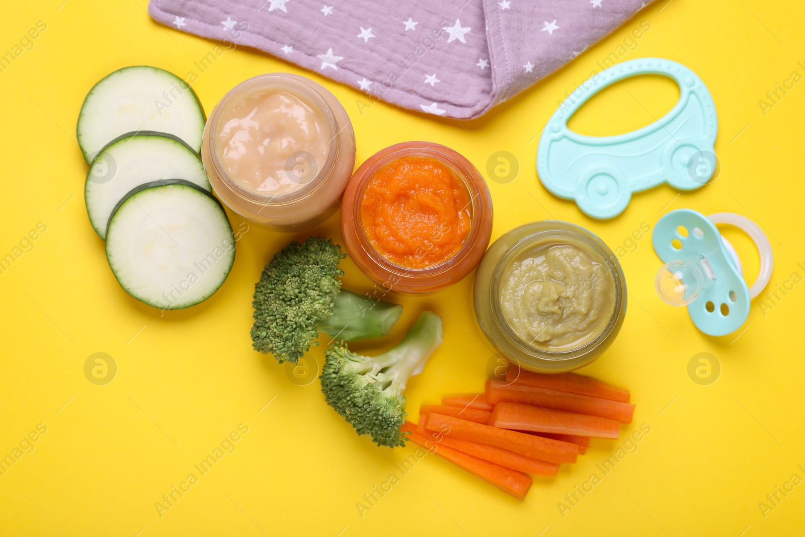 Photo of Flat lay composition with glass jars of healthy baby food and vegetables on yellow background