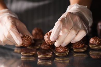 Woman packing delicious candies at production line, closeup