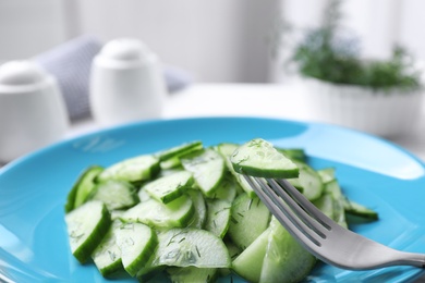 Plate of tasty cucumber salad on table, closeup