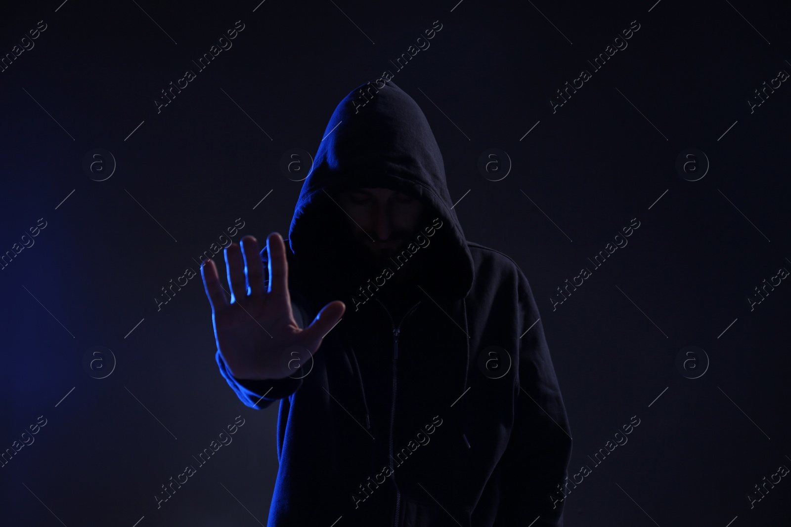 Photo of Man in hood on dark background. Cyber crime