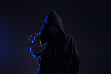 Man in hood on dark background. Cyber crime