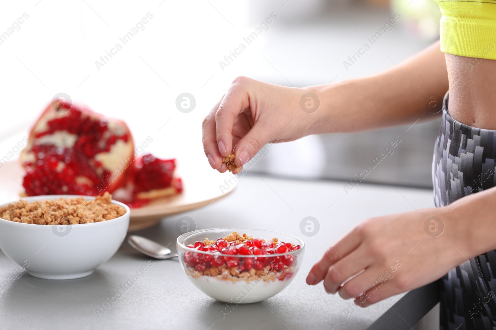 Photo of Young woman in fitness clothes preparing healthy breakfast at home, closeup