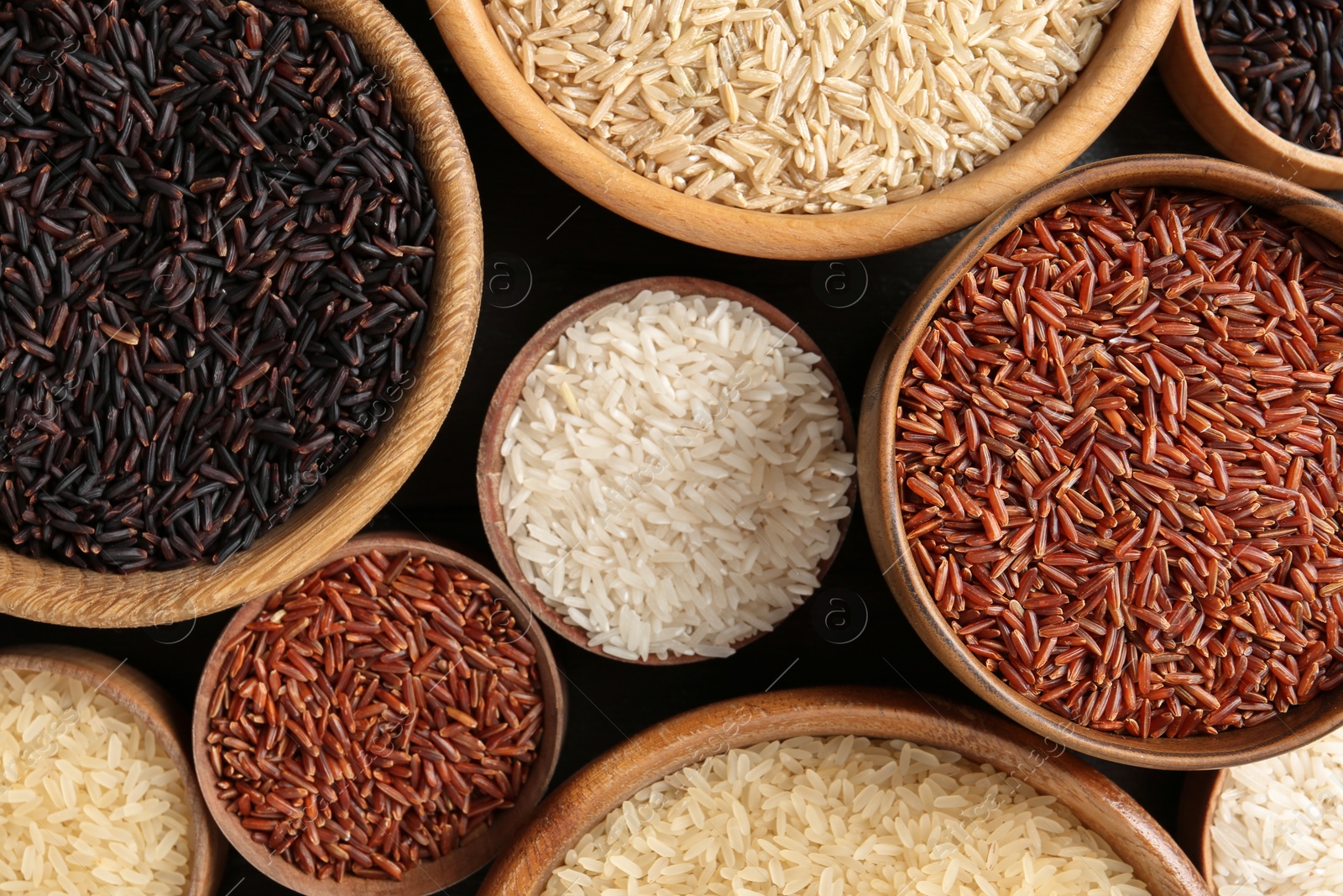 Photo of Flat lay composition with brown and other types of rice in bowls