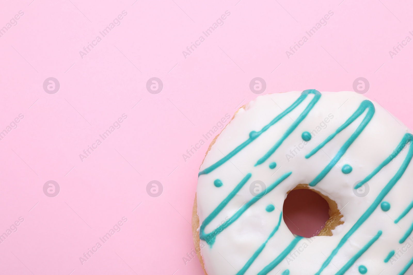 Photo of Tasty glazed donut on pink background, top view. Space for text