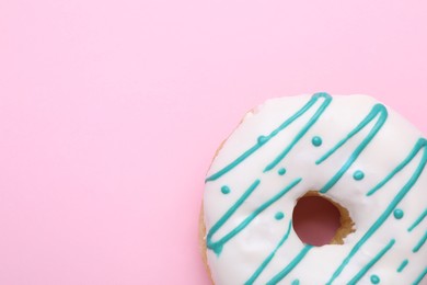 Photo of Tasty glazed donut on pink background, top view. Space for text
