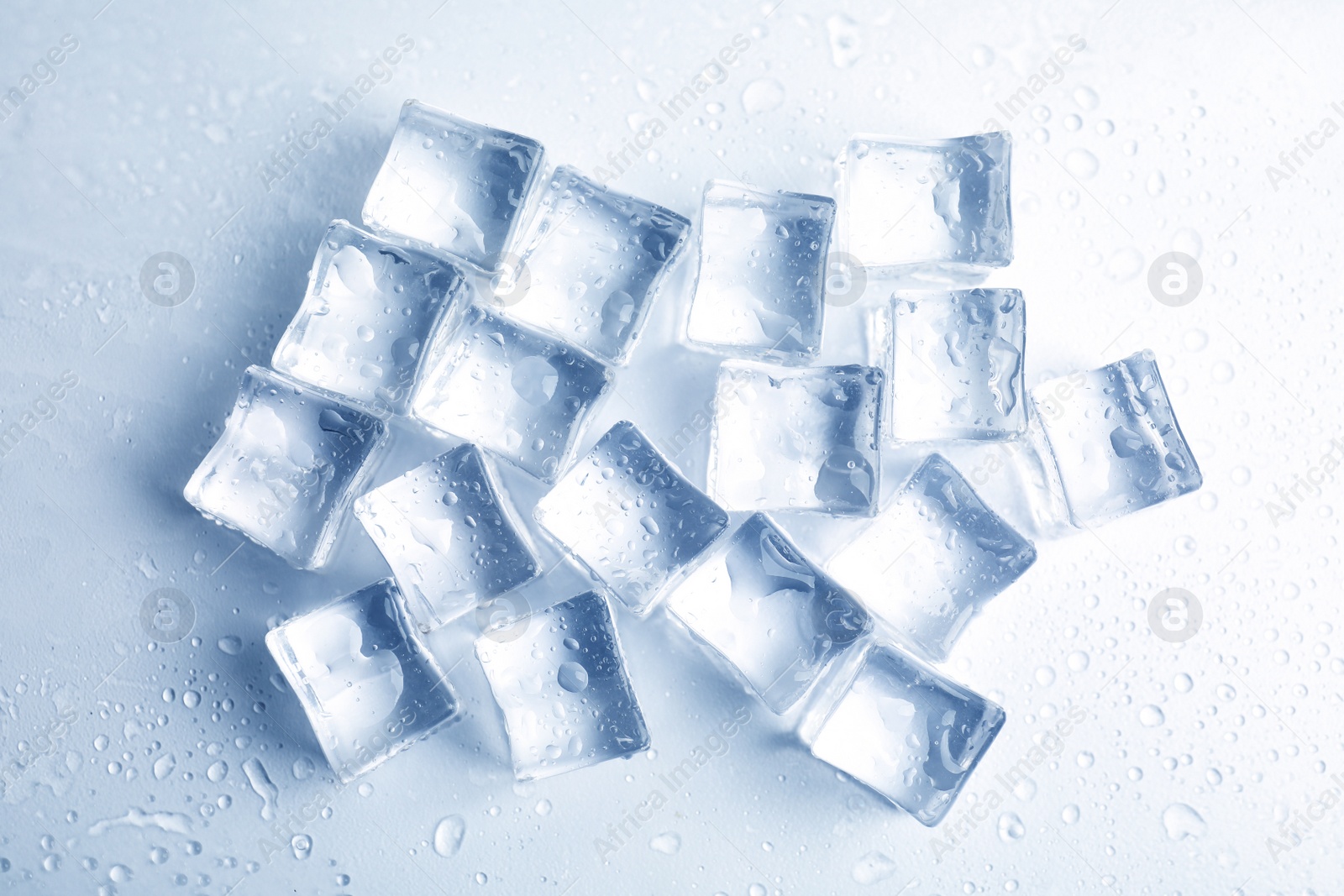 Photo of Ice cubes with water drops on white background, top view