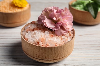 Photo of Different types of aromatic sea salt on white wooden table, closeup