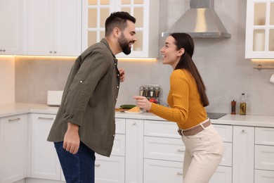 Happy lovely couple dancing together in kitchen