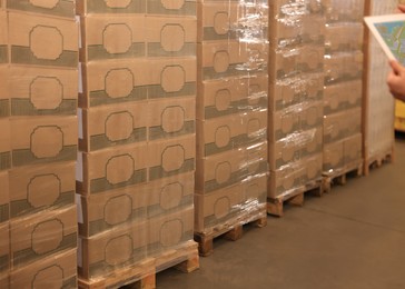 Image of Man with tablet working at warehouse, closeup. Logistics center