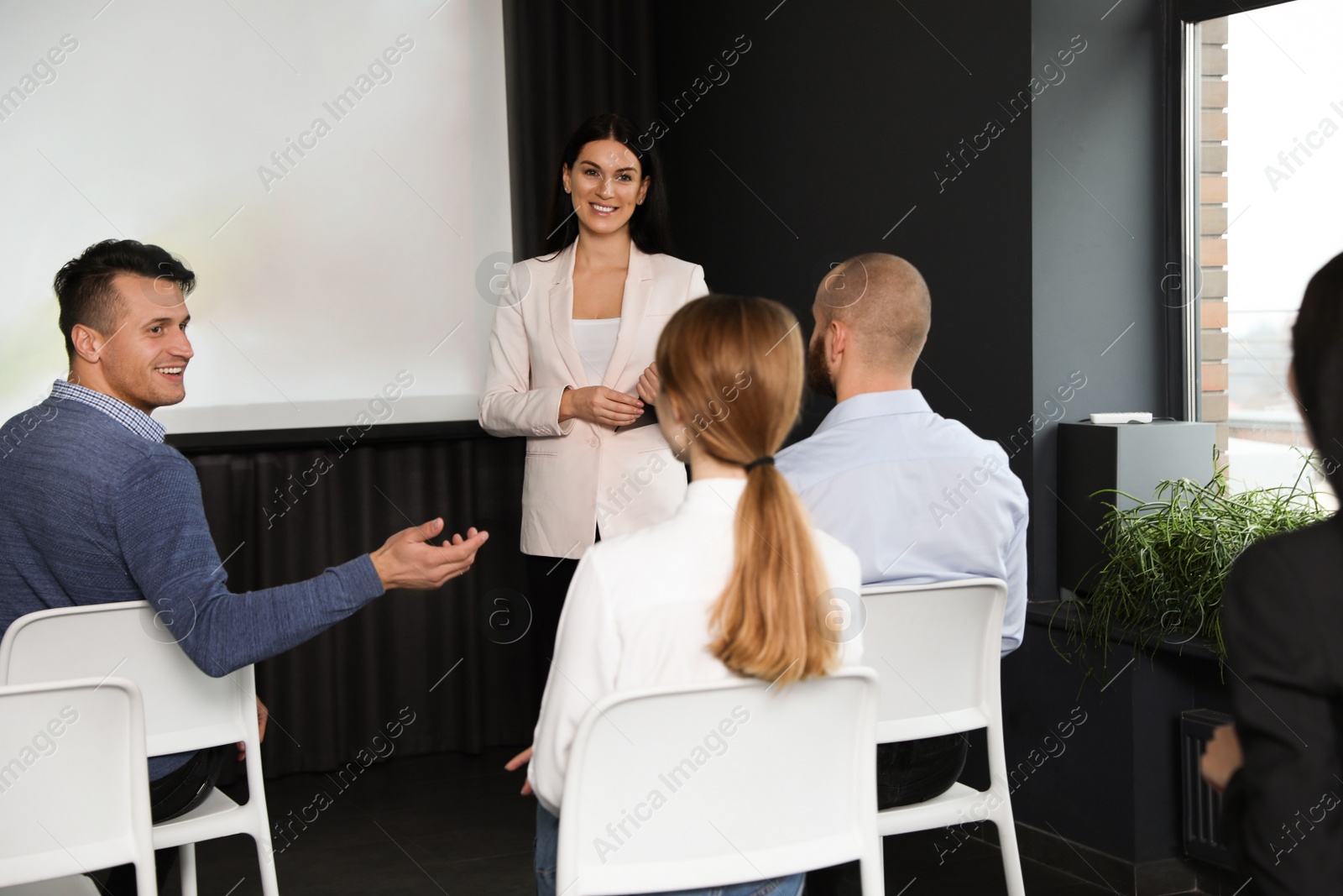 Photo of Business people at seminar in conference room with video projection screen