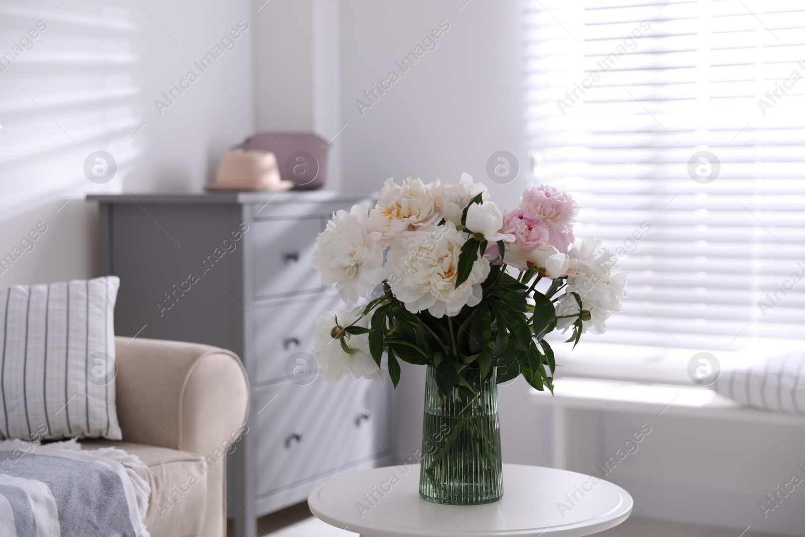 Photo of Bouquet of beautiful peony flowers on table indoors