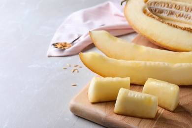 Photo of Sliced delicious ripe melon on grey marble table, closeup. Space for text