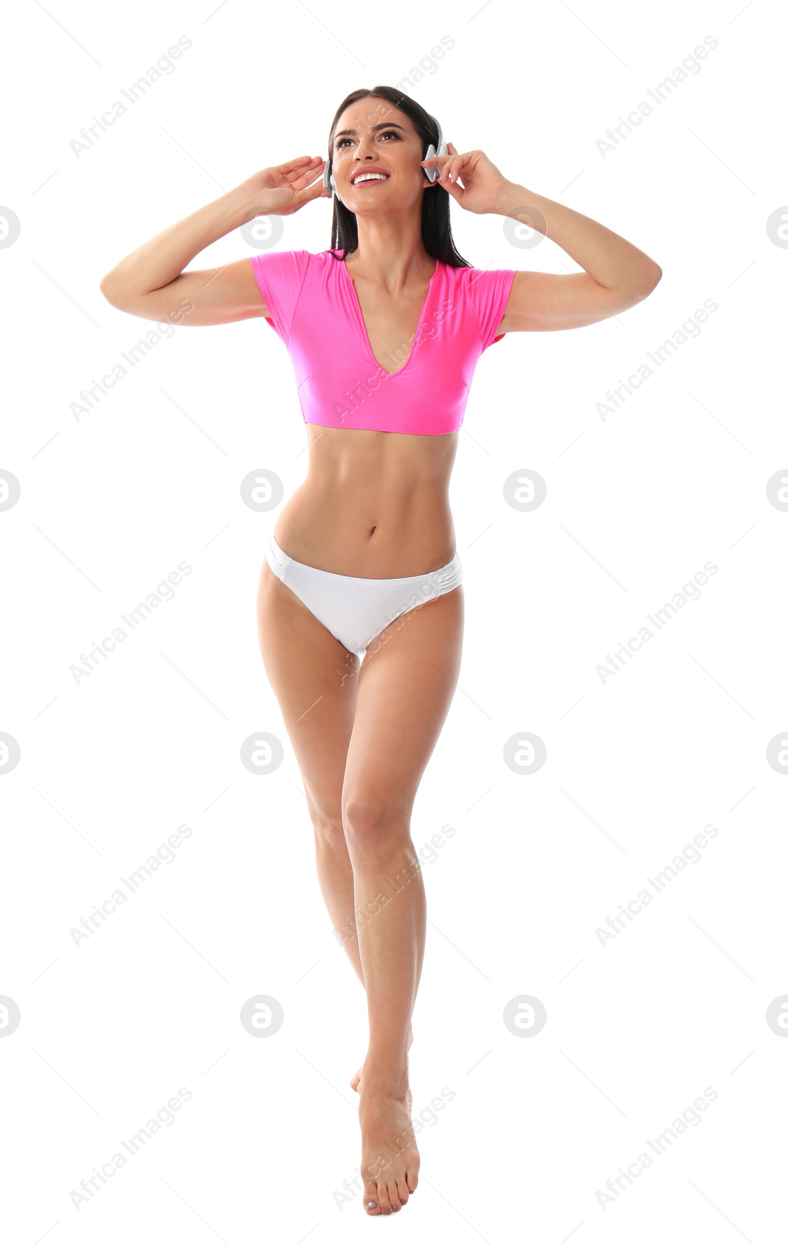 Photo of Beautiful young woman in stylish bikini with headphones on white background