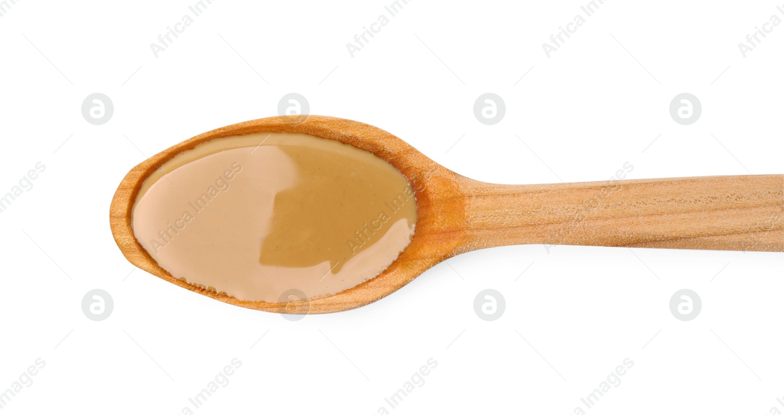 Photo of Wooden spoon with tasty peanut butter isolated on white, top view