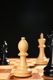 Photo of Different game pieces on chessboard against dark background, space for text