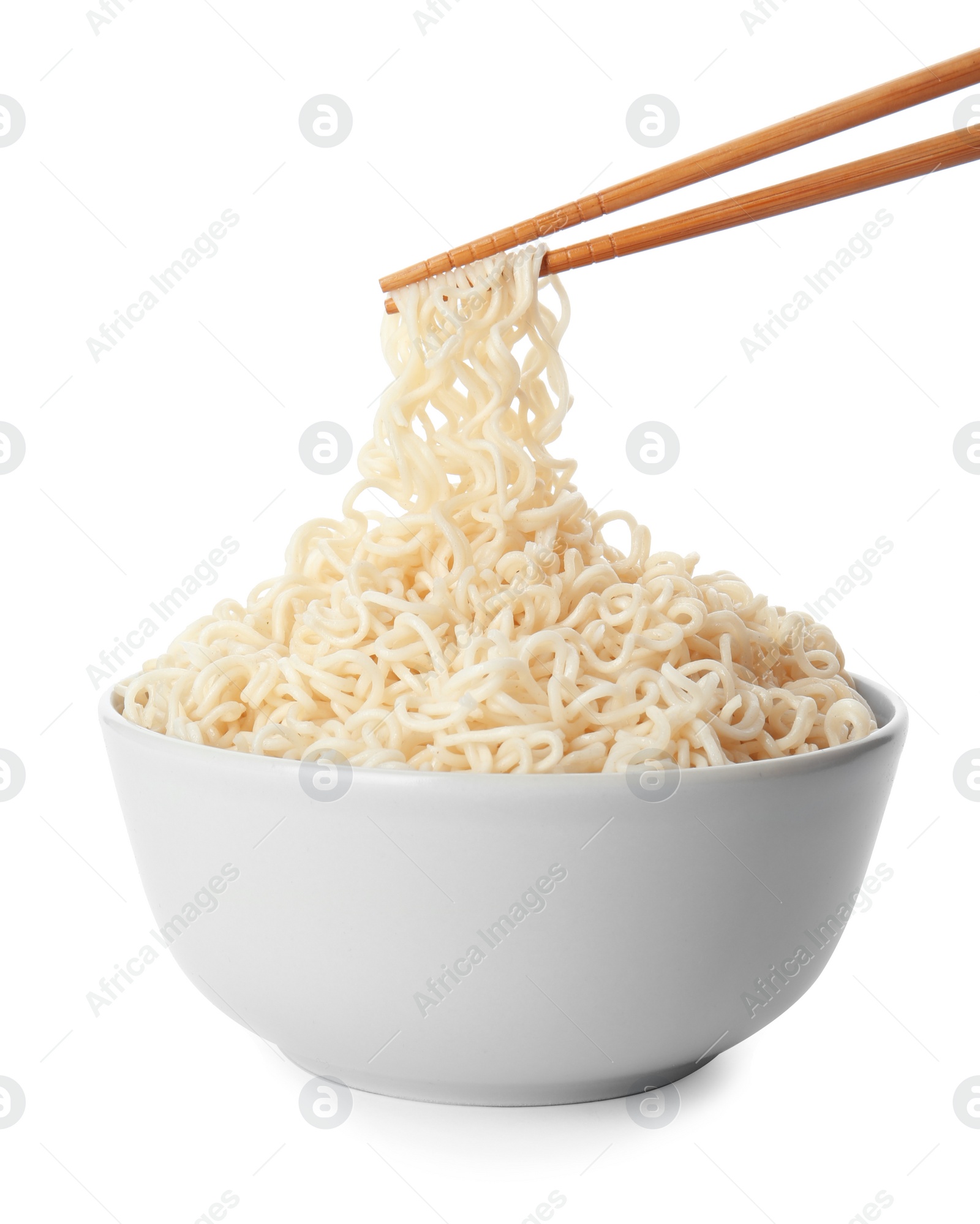 Photo of Chopsticks with tasty instant noodles over bowl isolated on white