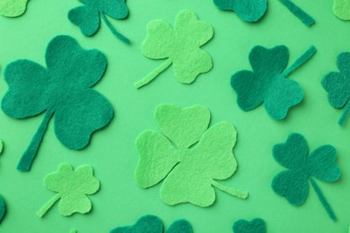 St. Patrick's day. Decorative clover leaves on green background, flat lay