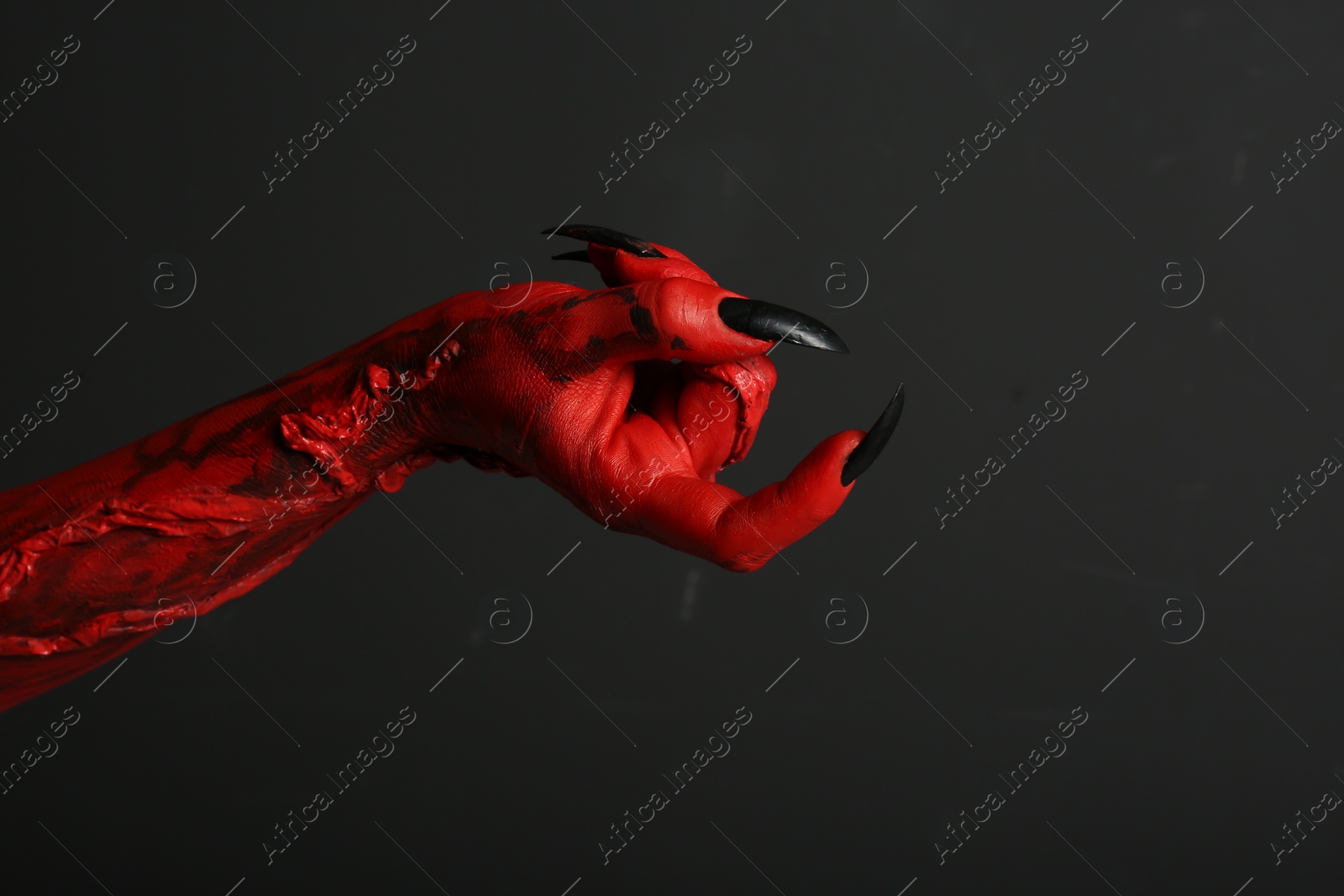 Photo of Scary monster on black background, closeup of hand. Halloween character