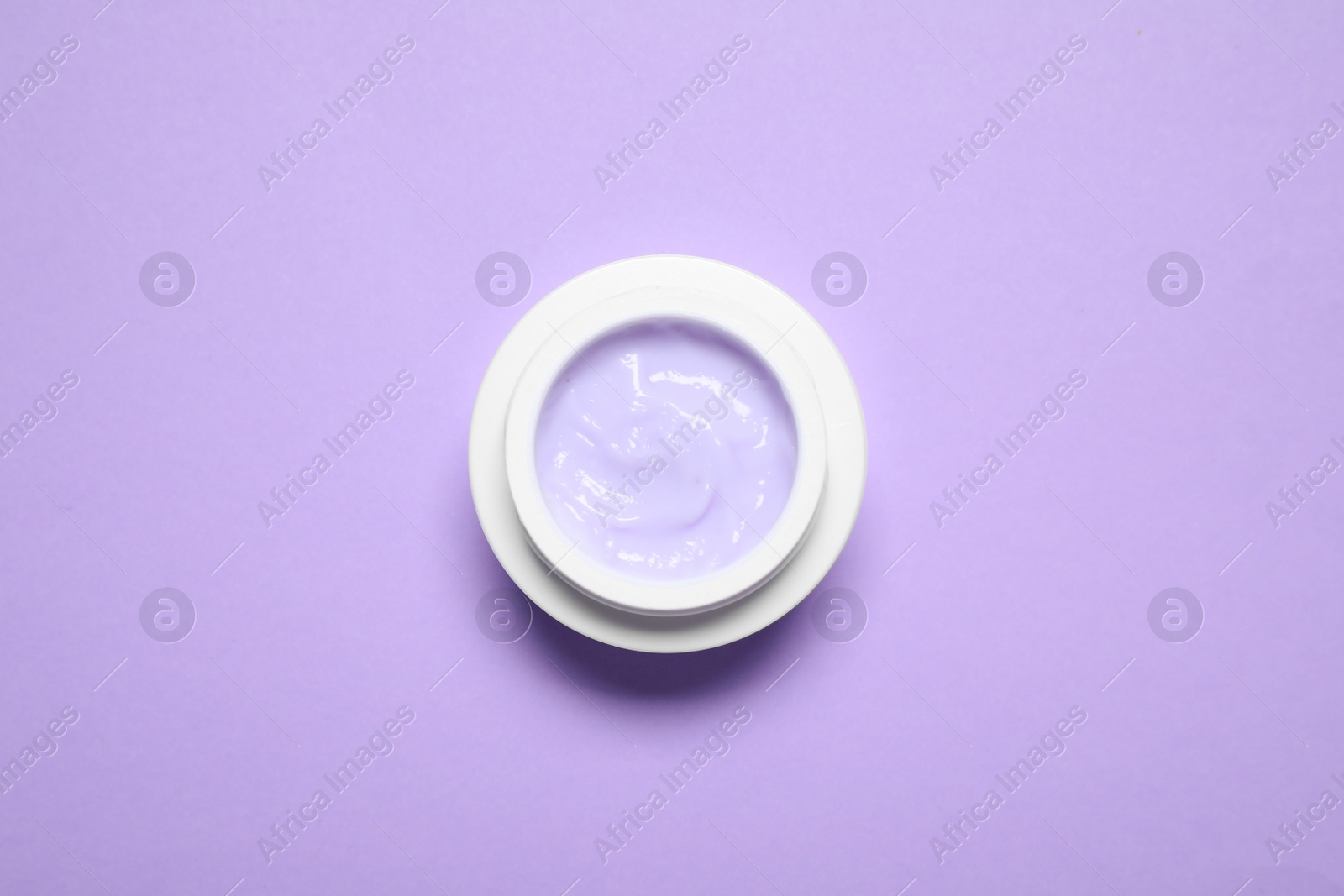Photo of Jar of organic cream on violet background, top view