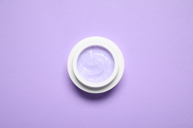 Photo of Jar of organic cream on violet background, top view