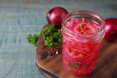 Jar with tasty pickled onions on wooden table