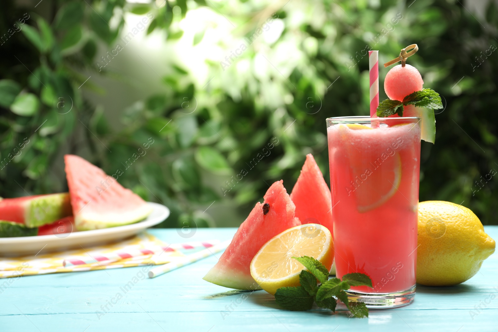 Photo of Delicious fresh watermelon drink on light blue wooden table. Space for text