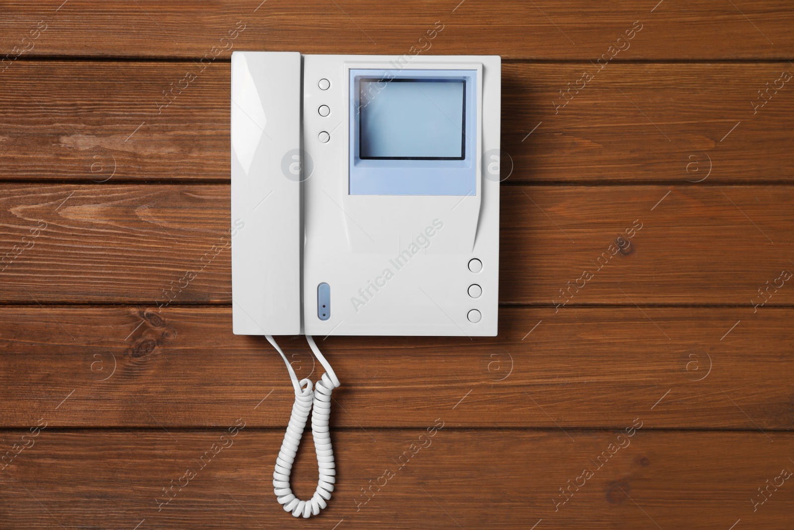 Photo of Modern intercom system with handset on wooden background, top view