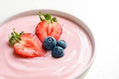 Photo of Bowl with delicious yogurt and berries, closeup