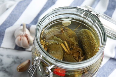 Photo of Jar with pickled cucumbers on table, closeup view