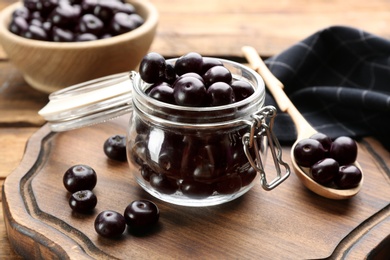 Fresh acai berries in glass jar on wooden table