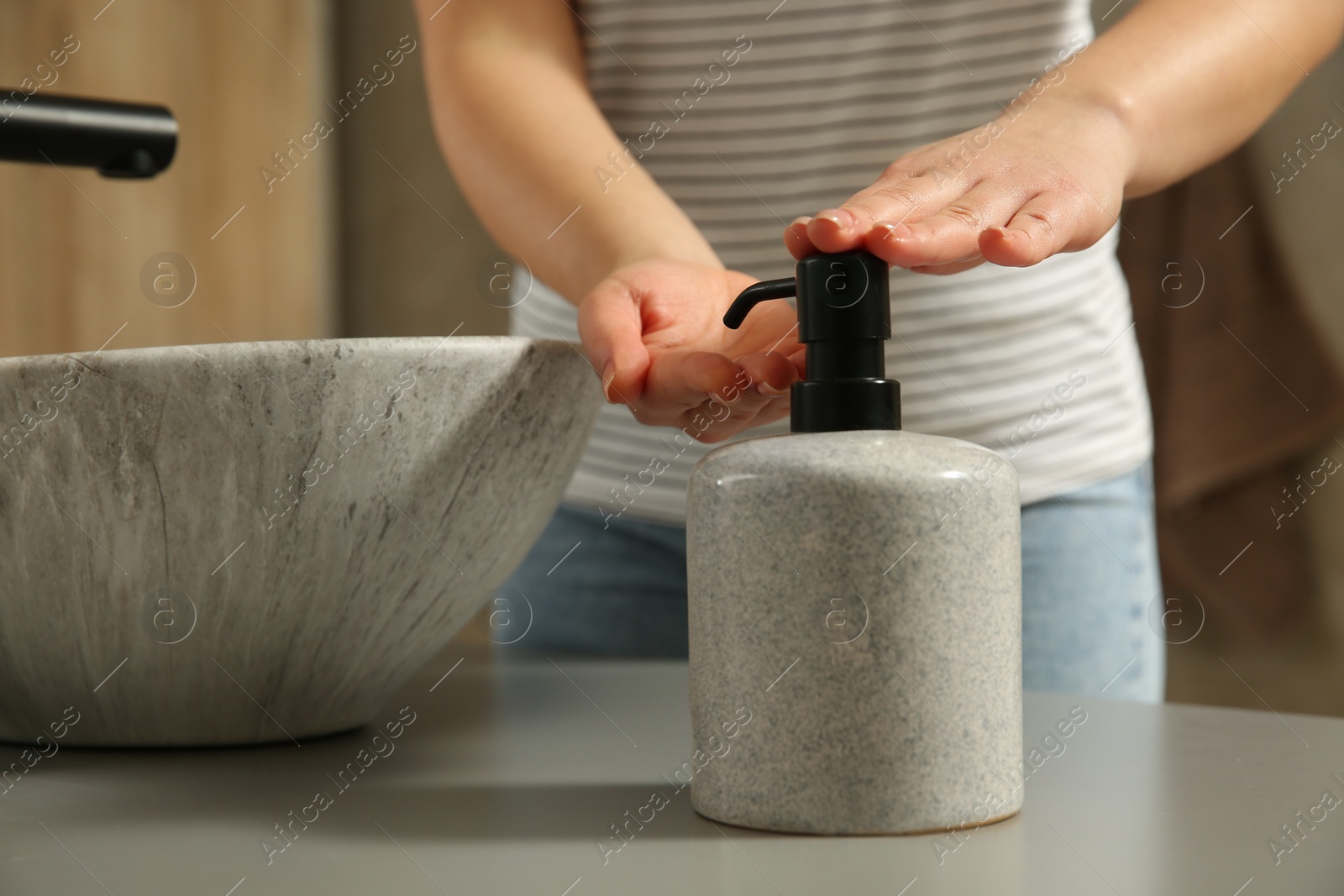 Photo of Woman washing hands with liquid soap in bathroom, closeup