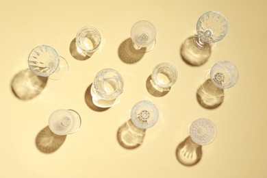 Photo of Set of empty glasses on beige background, flat lay
