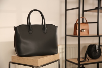 Photo of Elegant black bag on table in luxury boutique