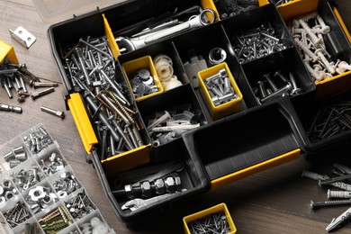 Photo of Organizers with many different fasteners and wrenches on wooden table, above view