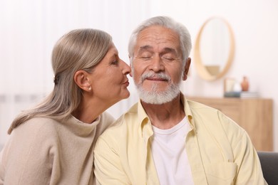 Senior woman kissing her beloved man at home