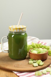 Photo of Celery juice in mason jar and fresh vegetables on table