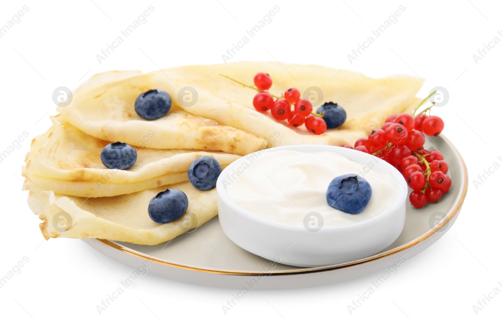 Photo of Delicious crepes with natural yogurt, blueberries and red currants on white background