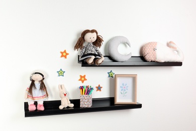 Photo of Cute toys and picture on shelves in child room