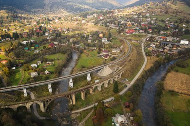 Image of Aerial view of bridges and village on autumn day