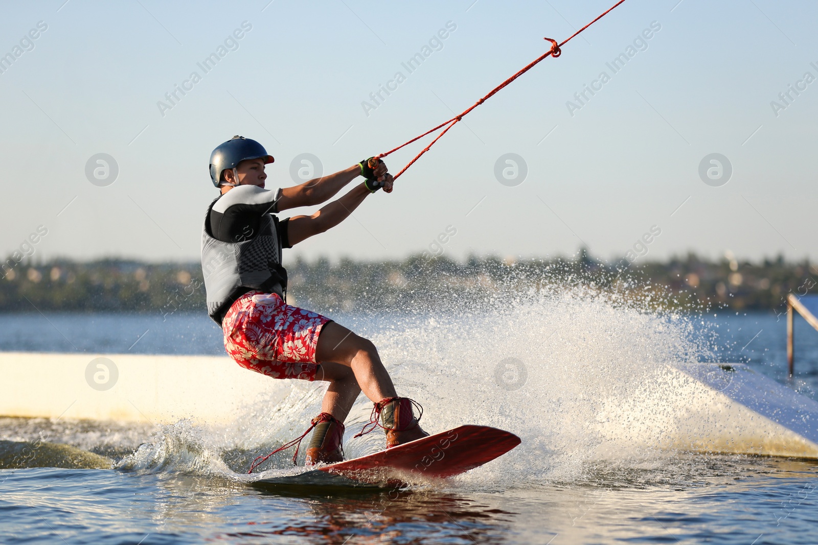 Photo of Teenage boy wakeboarding on river. Extreme water sport