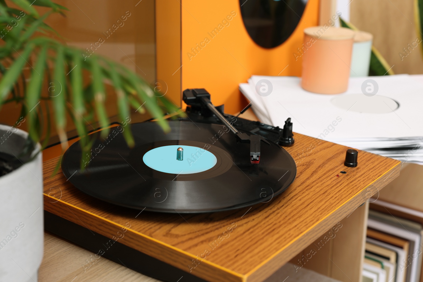 Photo of Stylish turntable with vinyl record on console table indoors