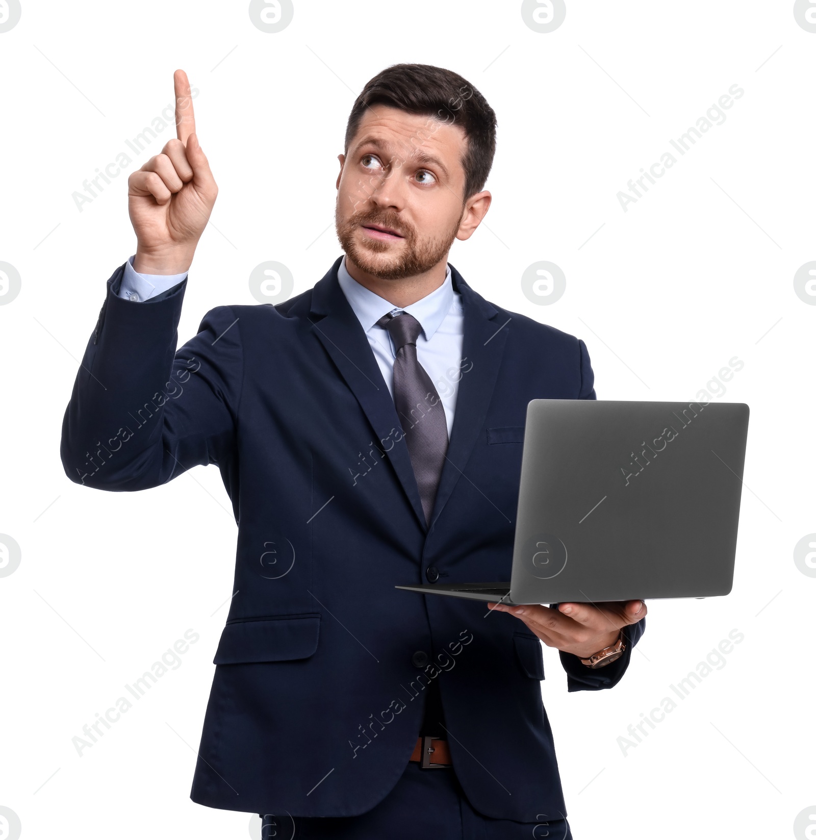 Photo of Handsome bearded businessman in suit with laptop pointing at something on white background