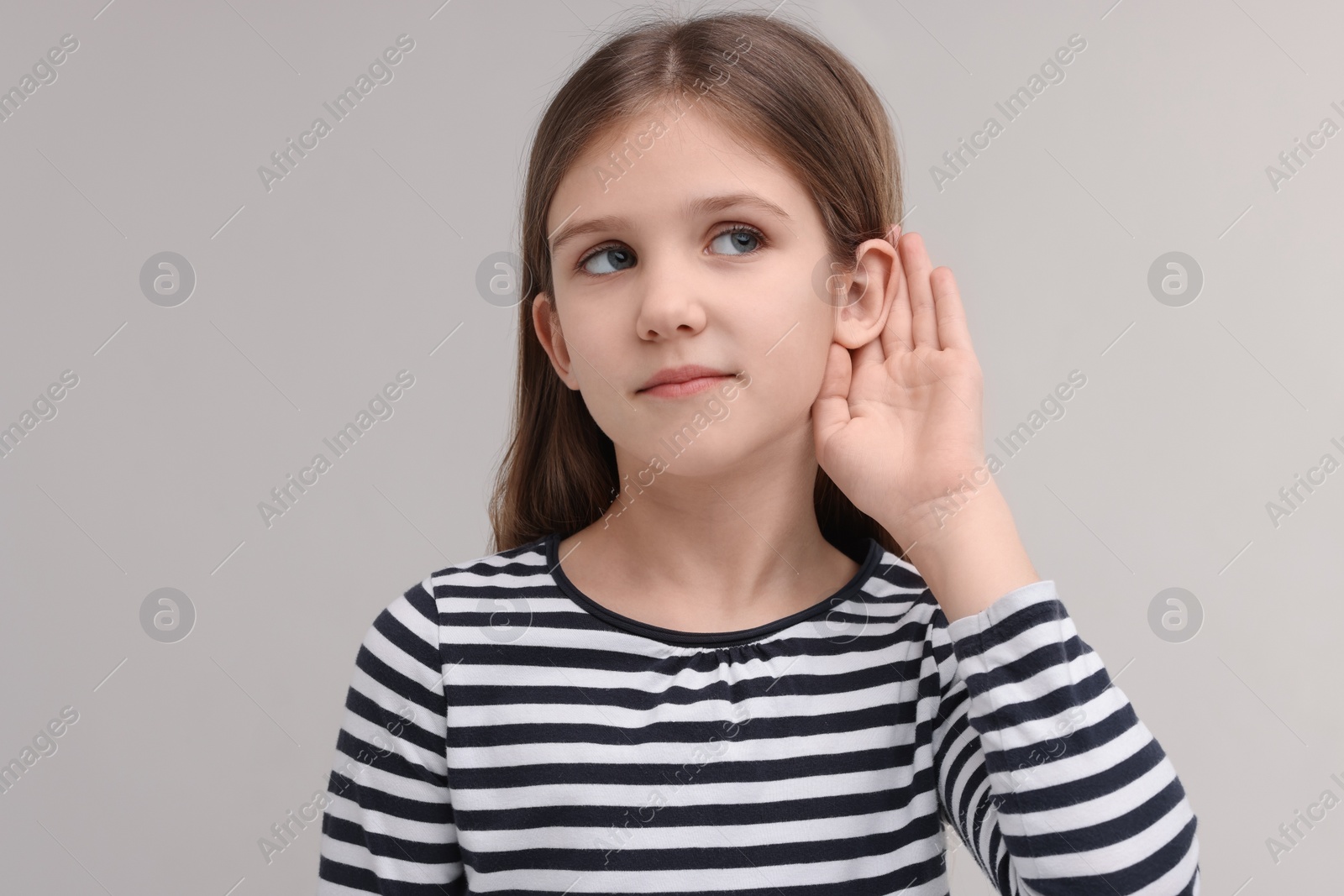 Photo of Little girl with hearing problem on grey background