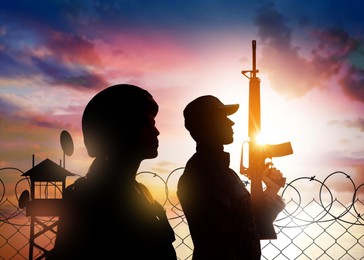 Image of Silhouettes of border guards at post outdoors in early morning