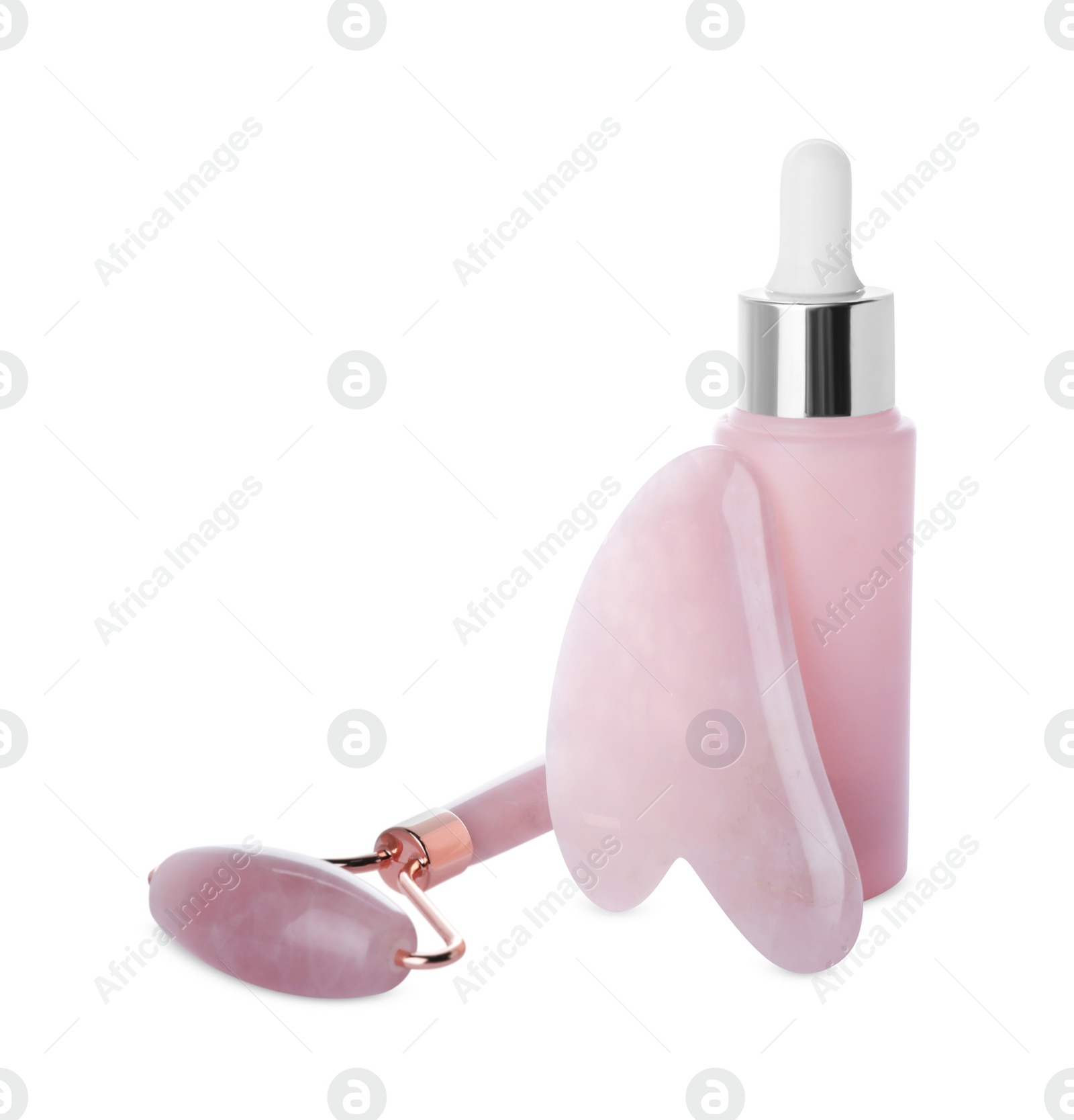 Photo of Rose quartz gua sha tool, facial roller and bottle of serum isolated on white